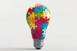 © Людмила Мазур - A colorful puzzle piece light bulb. The light bulb is made of many different colored pieces, and it is sitting on a white background. Concept of creativity and playfulness