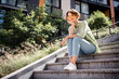 © deagreez - Full length photo of adorable lovely dreamy girl dressed stylish clothes sitting on stairs in green park fresh air sunny weather sunlight