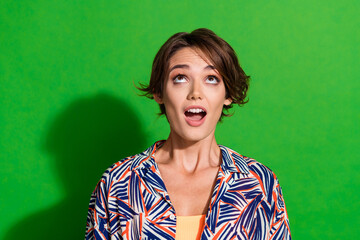 Sticker - Photo of astonished woman with bob hairstyle dressed print blouse look at impressive offer empty space isolated on green color background