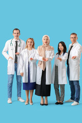 Poster - Professional team of doctors with red ribbons on blue background. World AIDS Day concept