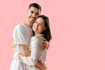 Wall Mural - Happy young couple on pink background