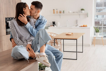 Wall Mural - Happy young couple kissing at home