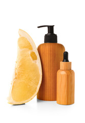 Wall Mural - Bottles of cosmetic products and slice of pomelo on white background