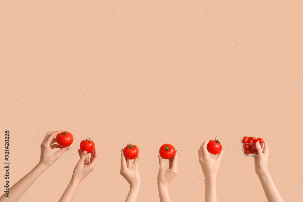 Hands with fresh tomatoes on beige background