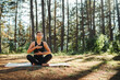 © Dusan - Young caucasian woman doing yoga stretching and meditating in forest