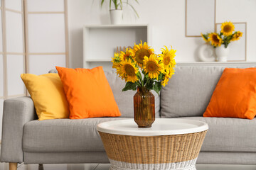 Poster - Stylish living room with grey sofa and vases of sunflowers bouquets on coffee table