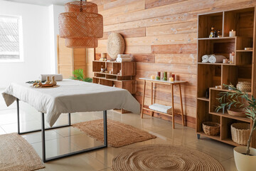 Wall Mural - Interior of stylish spa salon with couch, burning candles and wooden furniture