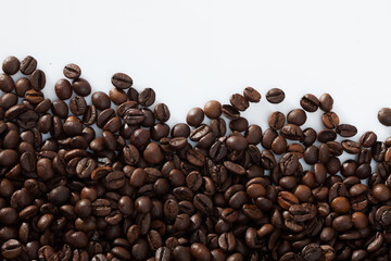 Roasted coffee beans on white surface. Natural food background..