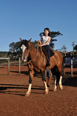 Wall Mural - menina vaqueira cavalgando com cavalo marrom 