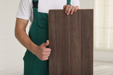 Wall Mural - Worker with samples of wooden flooring showing thumbs up indoors, closeup