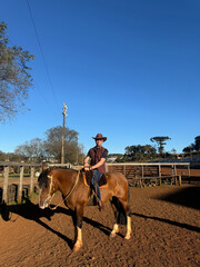 Wall Mural - homem vaqueiro em cavalgada com cavalo marrom 