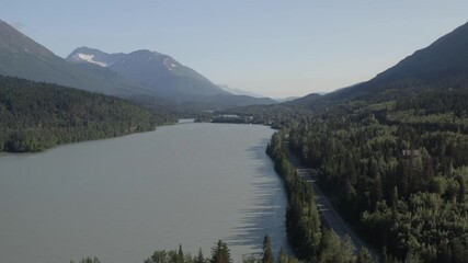 Poster - Panoramic view of lake and cars traveling along Seward Highway with scenic mountain landscape on Kenai Peninsula of Alaska - 4K Drone