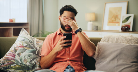 Bad news, phone and stress with man on sofa in living room of home, reading text message notification. Annoyed, fail and mistake with frustrated person in apartment for missed appointment on calendar