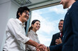 © Kawee - Asian business people making a handshake together while stand in office.