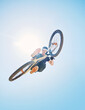 © Michael Cunningham/peopleimages.com - Extreme sports, jump and portrait of man on bicycle for training, workout and exercise on blue sky. Fitness, cycling and low angle of person on mountain bike for adventure, freedom and adrenaline