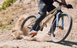 © Michael Cunningham/peopleimages.com - Action, sand and person on bicycle for riding, fitness and exercise outdoor with race, speed or dirt. Athlete, performance and off road mountain bike cycling for adventure, sport or workout in nature