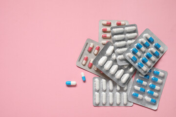 Wall Mural - Antibiotic pills in blisters on pink background, top view. Space for text