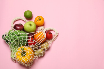 Canvas Print - Delivery of vegetarian products. String bag with different vegetables and fruits on pink background, top view. Space for text