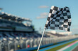 © Moon - Checkered racing flag waving against clear blue sky