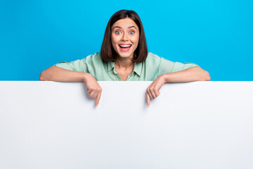 Wall Mural - photo of overjoyed woman dressed teal shirt indicating at awesome offer on billboard empty space iso