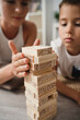 © blackday - Mother and her young son play with wooden blocks on the floor