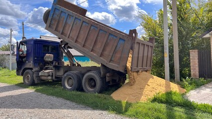 A truck brought sand for the construction site. Bulk cargo delivery