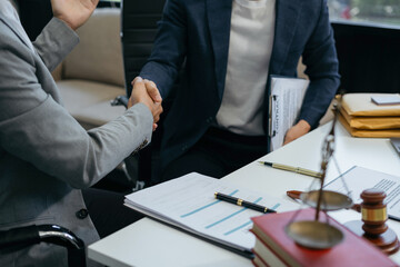 Middle age partner lawyers attorneys shaking hands after discussing a contract agreement done.