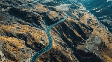 Wall Mural - Top view of a winding road with dramatic elevation changes through rugged mountain terrain. Ideal for adventure and travel imagery