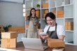 © wichayada - Happy Couple Packing Boxes and Managing Online Sales Together in a Modern Home Office