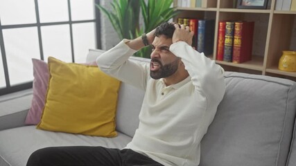 Sticker - Angry young hispanic man at home, furious and frustrated, caught in aggressive rage, mad screaming and shouting unleashes his inner anger