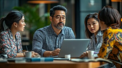 Wall Mural - A group of people are sitting around a table with a laptop open