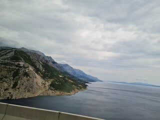 scenic landscape of mountains and sea on a cloudy summer day. people hurry up to vacation on of beau