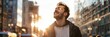 © Naru - A man stands on a city street, looking up at the sun with a happy smile, symbolizing positivity, optimism, hope, urban life and the beauty of nature.