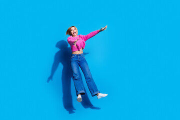 Wall Mural - Full body portrait of nice young woman jump fall wear sweater isolated on blue color background