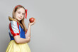 © millaf - Happy child girl theater actress holding red apple on white background with copy space