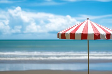 Wall Mural - Serene beach day with red white umbrella the ocean