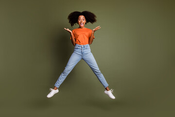 Sticker - Full length photo of adorable impressed girl wear orange clothes jumping high empty space isolated khaki color background