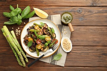 Wall Mural - Delicious salad with grilled vegetables, basil, pesto sauce, pine nuts and fork on wooden table, flat lay. Space for text