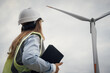 © YURIMA - A dedicated female engineer is diligently inspecting a wind turbine at a renewable energy site, showcasing her commitment to progress and sustainability in the field of engineering and innovation