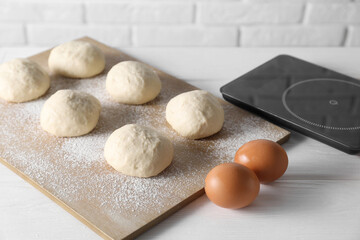 Canvas Print - Raw dough balls, eggs and kitchen scale on white wooden table