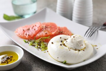 Sticker - Delicious burrata cheese, grapefruit and spices on grey table, closeup