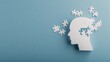 © pvl0707 - Creative exploration of mental health represented by a white paper cutout of a human head with puzzle pieces falling against a blue background in a minimalistic flat lay