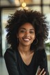 © vefimov - African-American woman in office, smiling and posing for photo.