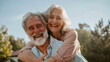 © SerPak - Senior couple sharing a joyful moment with a hearty laugh in a sunny, natural setting