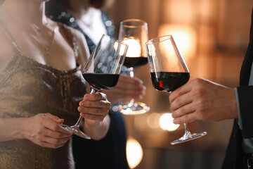 Wall Mural - Women and man clinking glasses of tasty wine at party, closeup