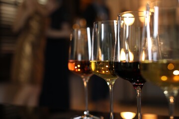 Sticker - Different tasty wines in glasses on table indoors, selective focus