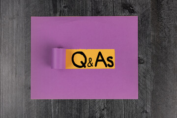 Question and Answers, Q & As Handwritten on yellow and purple construction paper flat lay background