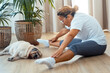© simona - Middle age lady doing home workout in living room with sleeping dog near her. Cozy and healthy indoor leisure lifestyle. One woman in daily workout routine fit body health concept. Stretching legs