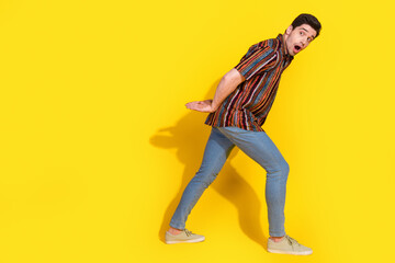 Wall Mural - Full length portrait of nice young man look carry empty space wear shirt isolated on yellow color background