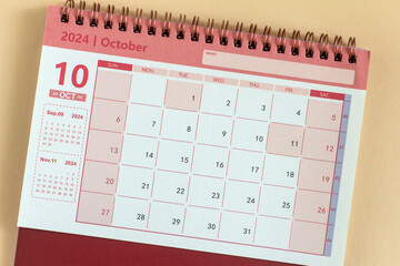 Wall Mural - Desk calendar for October 2024 on a beige background.